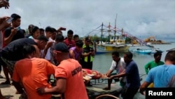 Penjaga Pantai Filipina membawa jenazah seorang nelayan di pantai Infanta, Provinsi Pangasinan, Filipina, 3 Oktober 2023, setelah insiden tabrakan mematikan di Laut Cina Selatan. (Penjaga Pantai Filipina/Handout via REUTERS)