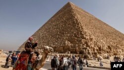 Turis mengunjungi Piramida Besar Khufu (Cheops) di pekuburan Piramida Giza, pinggiran barat daya Kairo, 2 Maret 2023. (Khaled DESOUKI / AFP)