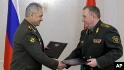 Russian Defense Minister Sergei Shoigu, left, and Belarusian Defense Minister Viktor Khrenin, during a meeting after a session of the Council of Defense Ministers of the Collective Security Treaty Organization (CSTO) in Minsk, Belarus, Thursday, May 25, 2023. 