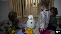 แฟ้ม - เด็กเล่นกับหุ่นยนต์และของเล่นพลาสติกที่กรุงปารีส ฝรั่งเศส เมื่อ 2 ก.พ. 2018 (Photo by CHRISTOPHE ARCHAMBAULT / AFP) / TO ILLUSTRATE THE EVENT AS SPECIFIED IN THE CAPTION