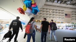 Una pareja de venezolanos se reúne en el Aeropuerto de Orlando, tras ella recibir el parole humanitario, el 31 de octubre de 2022. REUTERS/Phelan M. Ebenhack