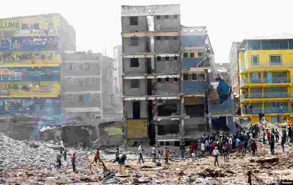 Scavengers of scrap metal search for their colleague under the rubble of a residential flat built on riparian land, that collapsed while undergoing demolition near the Mathare River, in Huruma District of Nairobi, Kenya.