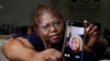 Janet Jarrett shows a photo of her sister, Pamela Jarrett, she keeps on her phone at the home they shared, July 19, 2024, in Spring, Texas. Pamela Jarrett passed away after suffering heat-related distress due to the power outage caused by hurricane Beryl.