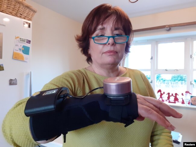 Enferma de Parkinson usa un guante giroscópico en su casa de Towcester, Reino Unido.
