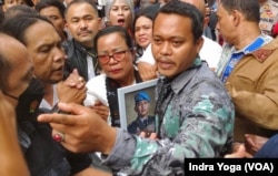 Ibunda Brigadir Yosua, Rosti Simanjuntak (tengah) menghadiri sidang putusan Ferdy Sambo dengan membawa foto anaknya. Rosti berterimakasih kepada majelis hakim yang telah memberikan putusan vonis hukuman mati kepada Ferdy Sambo. (VOA/Indra Yoga)