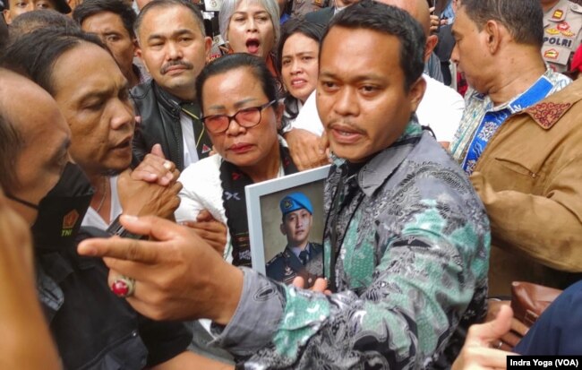 Ibunda Brigadir Yosua, Rosti Simanjuntak (tengah) menghadiri sidang putusan Ferdy Sambo dengan membawa foto anaknya. Rosti berterimakasih kepada majelis hakim yang telah memberikan putusan vonis hukuman mati kepada Ferdy Sambo. (VOA/Indra Yoga)