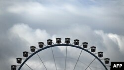 FILE - Clouds hang over a Ferris wheel during the Oktoberfest beer festival in Munich, southern Germany, Sept. 17, 2022. A Ferris wheel caught fire Saturday night at a music festival near Leipzig in eastern Germany, injuring at least 23 people, 