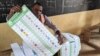 Un agent électoral prépare un bulletin de vote pour un électeur dans un bureau de vote à l'école primaire publique Hedzranawoe à Lomé, le 29 avril 2024, lors des élections législatives au Togo. (Photo par Emile KOUTON / AFP)