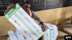 Un agent électoral prépare un bulletin de vote pour un électeur dans un bureau de vote à l'école primaire publique Hedzranawoe à Lomé, le 29 avril 2024, lors des élections législatives au Togo. (Photo par Emile KOUTON / AFP)