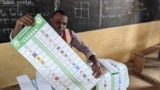 Um funcionário eleitoral prepara um boletim de voto na escola primária pública de Hedzranawoe, em Lomé, a 29 de abril de 2024, durante as eleições legislativas do Togo.