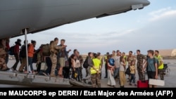 French and other nationalities disembark at a French military air base in Djibouti, April 23, during their evacuation from Sudan on the first French flight out of the war-hit country.