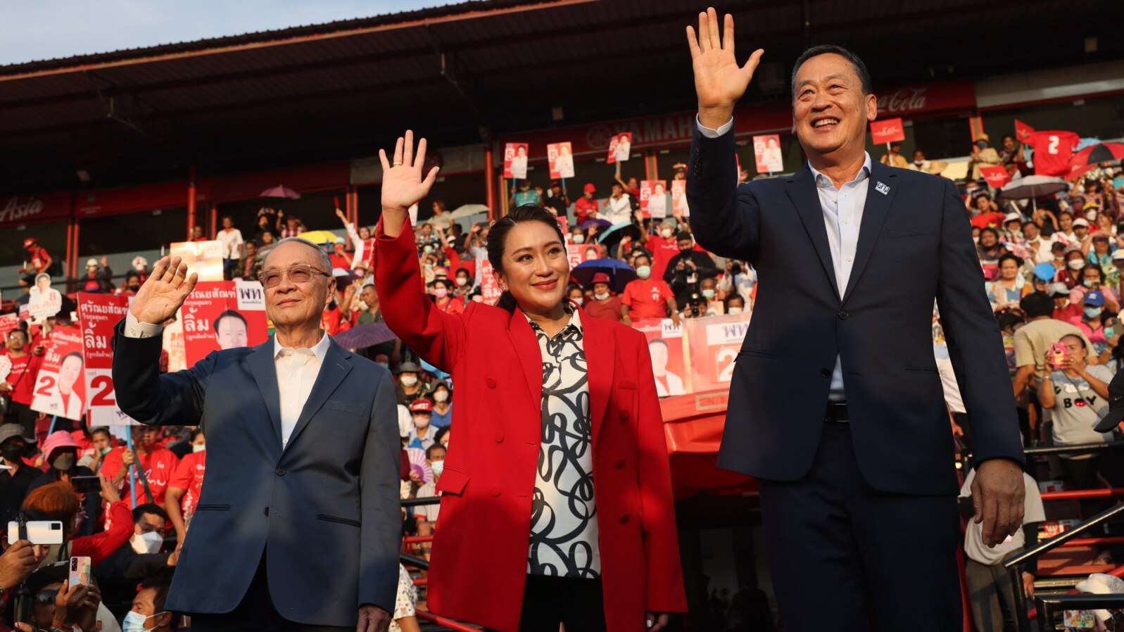 Thai candidates for prime minister Chaikasem Nitisiri, left, Paetongtarn Shinawatra, center, and Srettha Thavisin, right, wave during a rally for Thailand's main opposition Pheu Thai party at the Thunder Dome Stadium north of Bangkok, April 5, 2023.