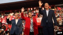 Thai candidates for prime minister Chaikasem Nitisiri, left, Paetongtarn Shinawatra, center, and Srettha Thavisin, right, wave during a rally for Thailand's main opposition Pheu Thai party at the Thunder Dome Stadium north of Bangkok, April 5, 2023.