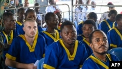 L'Américain Taylor Thomson (deuxième à gauche) assis parmi d'autres accusés de la tentative de coup d'État du 19 mai, lors de la séance d'ouverture du procès à la prison de Ndolo, à Kinshasa, le 7 juin 2024.