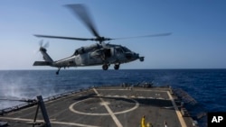 12일 홍해에서 작전을 수행 중인 알레이 버크급 유도 미사일 구축함 USS 라분에서 HSC-7 헬리콥터가 착륙하고 있다. (자료하면)