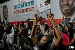 People gather outside anti-establishment candidate Bassirou Diomaye Faye's headquarters in Dakar, on March 24, 2024.