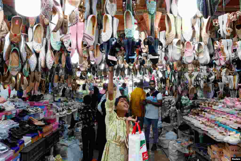 A girl looks at sandals for sale at a market ahead of the Eid al-Fitr festival, which marks the end of the Muslim fasting month of Ramadan, in Kolkata, India.