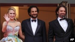 Dari kiri ke kanan, aktris Maria Bakalova, sutradara Ali Abbasi, dan aktor Sebastian Stan berpose untuk para fotografer saat tiba di pemutaran perdana film,"The Apprentice" di Festival Film Cannes, di Prancis, pada 20 Mei 2024. (Foto: Scott A Garfitt/Invision/AP)