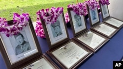 Photos of Hawaii men posthumously awarded Purple Heart medals sit on a table at Pearl Harbor, Hawaii, on May 10, 2024.