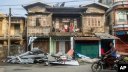 A local rides motorbike past damaged buildings after Cyclone Mocha in Sittwe township, Rakhine State, Myanmar, Monday, May 15, 2023. (AP Photo, File)