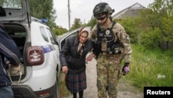 一名警察在俄罗斯袭击乌克兰期间帮助哈尔科夫地区沃夫昌斯克镇居民疏散至哈尔科夫。（2024年5月13日）