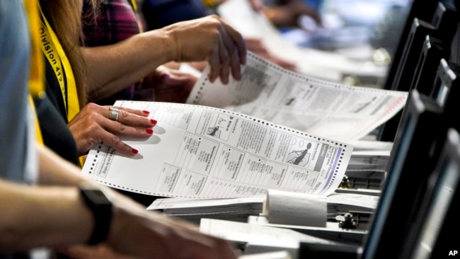 FILE - Election workers perform a recount of ballots from the recent Pennsylvania primary election at the Allegheny County Election Division warehouse in Pittsburgh on June 1, 2022.