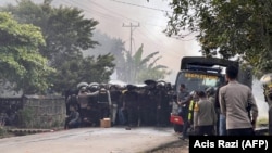 Aparat kepolisian membubarkan warga di Wamena setelah 10 orang tewas dalam kerusuhan yang dipicu oleh desas-desus penculikan anak, 23 Februari 2023. (Foto: AFP/Acis Razi)