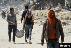 Palestinians carry a bag of aid in Gaza City during the Israel-Hamas war, April 3, 2024.