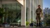 An armed security person stands stand guard at the gate of a building housing BBC office in New Delhi, India, Feb. 15, 2023.