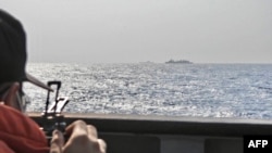 FILE - A Taiwanese navy soldier monitors China's Shandong aircraft carrier at sea, east of Taiwan, in this handout picture taken and released by Taiwan's defense ministry on April 5, 2023.