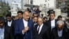 Iranian Foreign Minister Hossein Amir-Abdollahian, center left, walks with his Syrian counterpart Faisal Mekdad, center right, and Iran's Ambassador to Syria Hossein Akbari, center, during a visit to the site destroyed by airstrikes, in Damascus on April 8, 2024. 