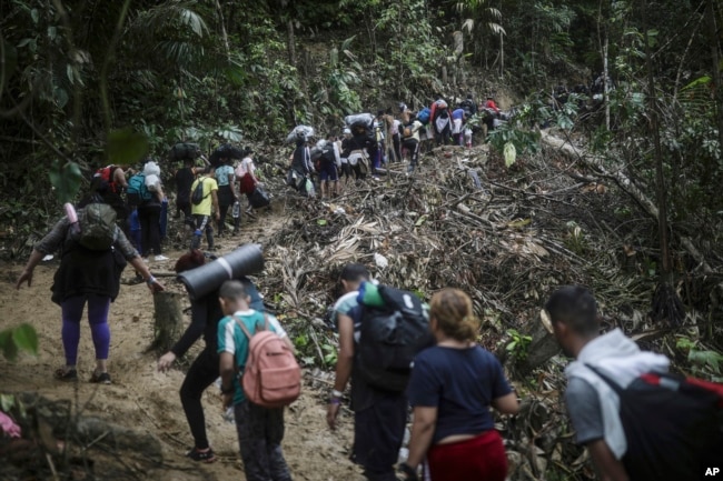 FILE - Migrants walk across the Darien Gap from Colombia to Panama on their long and difficult journey to reach the United States, on May 9, 2023. (AP Photo/Ivan Valencia)