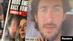 A woman holds a sign as relatives and supporters rally in Tel Aviv, Israel, on Dec. 16, 2023, for the release of hostages kidnapped from Israel by Hamas on October 7.