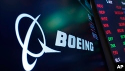 FILE - The logo for Boeing appears on a screen above a trading post on the floor of the New York Stock Exchange, July 13, 2021. 