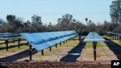 Rows of solar panels line up at the Orsted Eleven Mile Solar Center lithium-ion battery energy storage facility Thursday, Feb. 29, 2024, in Coolidge, Arizona.