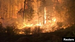 Fire burns close to a highway near Sorrento, British Columbia, Canada, on Aug. 18, 2023, in this screen grab obtained from social media video. (Nikki Goyer via REUTERS)