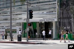 Shoppers queue to enter Louis Vuitton on Rodeo Dr in Beverly Hills, California, Tuesday, April 20, 2021. (AP/Ashley Landis)