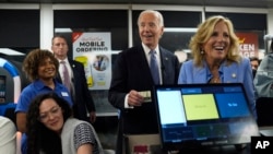 President Joe Biden, center, and first lady Jill Biden, right, pay for a purchase as they greet supporters at a Waffle House in Marietta, Georgia, June 28, 2024, following a presidential debate in Atlanta.