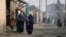 FILE - Burqa-clad Afghan women walk on a street in a neighborhood where mostly Afghan populations live, in Karachi, Pakistan, Jan. 26, 2024. 