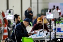 Workers of Iraq's Independent High Electoral Commission (IHEC) perform a manual count of votes to match the electronic count at one of the commission's headquarters in the Karkh district of Baghdad, Dec. 23, 2023