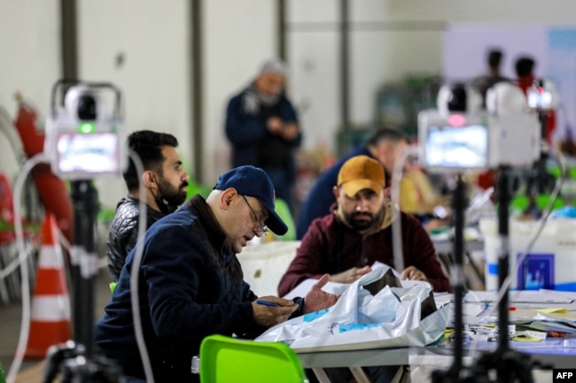 Workers of Iraq's Independent High Electoral Commission (IHEC) perform a manual count of votes to match the electronic count at one of the commission's headquarters in the Karkh district of Baghdad, Dec. 23, 2023