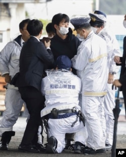 Seorang pria, tengah, tertangkap setelah sebuah alat dilemparkan ke Perdana Menteri Jepang Fumio Kishida saat berpidato di Wakayama, Jepang barat, 15 April 2023. (Foto: Kyodo via Reuters)