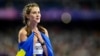 Gold medallist Ukraine's Yaroslava Mahuchikh celebrates, wrapped in a Ukrainian flag, after competing in the women's high jump final at the Paris 2024 Olympic Games at Stade de France in Saint-Denis, north of Paris, Aug. 4, 2024.