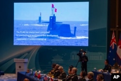 A screen shows Chinese submarines at the opening of the Western Pacific Navy Symposium in Qingdao, eastern China's Shandong province, April 22, 2024.