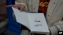 Tao Bolin, a 25-year-old influencer and science fiction fan, holds a signed copy of "The Three-Body Problem" outside the World Science Fiction Convention in Chengdu, China, Oct. 20, 2023.