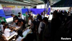 Para pemilih antre untuk memasukan suara di sebuah tempat pemungutan suara (TPS) di Bangkok, Thailand, Minggu, 14 Mei 2023. (Foto: Athit Perawongmetha/Reuters)