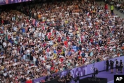 Spectators watch the 2024 Summer Olympics closing ceremony at the Stade de France, in Saint-Denis, France, Aug. 11, 2024.