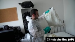 Pest control technician Lucas Pradalier sprays steam on a pillow in a Paris apartment, Wednesday, Oct. 4, 2023. The French government has been forced to step in to calm a nation increasingly anxious about bedbugs. (AP Photo/Christophe Ena)