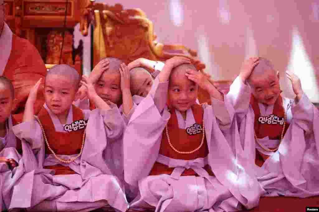 Young monks react after getting their heads shaved during an event to celebrate the upcoming Vesak Day, birthday of Buddha, at Jogye temple in Seoul, South Korea.