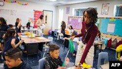 ILUSTRASI - Aisha Thomas (baju ungu) sedang belajar keterampilan mengajar bersama guru Alexxa Martinez, di Sekolah Dasar Nevitt, Phoenix, Arizona, 26 Oktober 2022. (Olivier TOURON / AFP)